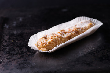 Almond eclair on dark background