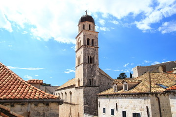 Belfry of the church in Dubrovnik and house roofs in summer sunny day