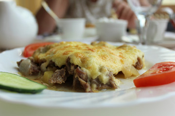 Baked meat with potatoes and cheese.