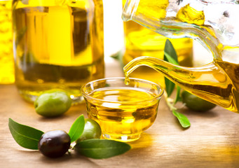 Olive oil. Bottle pouring virgin olive oil in a bowl