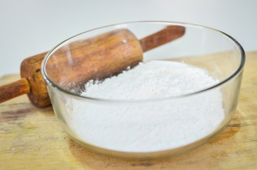 cake flour in glass bolw with wooden roller