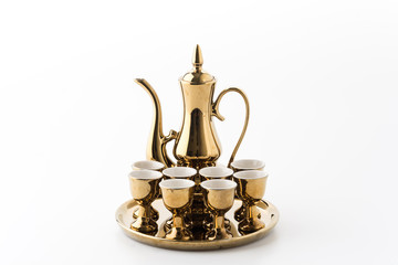 golden teapot and cup on white background