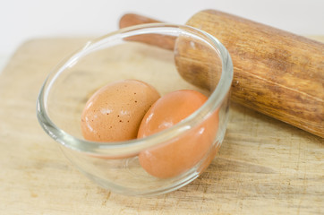 eggs in glass bolw on wooden board