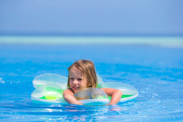 Fototapeta na wymiar Little happy adorable girl in outdoor swimming pool