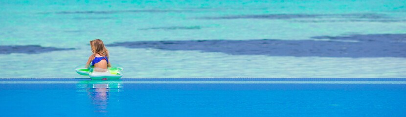 Little happy adorable girl in outdoor swimming pool