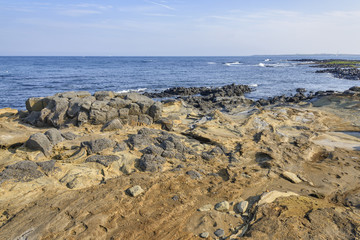 Fototapeta na wymiar Coast of Jeju island with Volcanic rocks