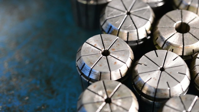 Camera sliding over CNC milling machine metal collets with changing light position 