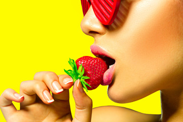 Fototapeta Sexy woman wearing red glamor sunglasses eating strawberry obraz
