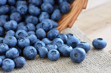 Blaubeeren - Heidelbeeren in Körbchen auf Jute mit Wassertropfen