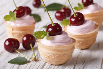 tartlets with pink cream and fresh cherry on the table
