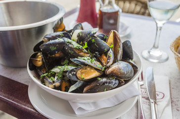 Fototapeta na wymiar A bowl of delicious moules mariniere (mussels) ready for lunch in a seafood restaurant in Brighton, East Sussex, UK