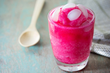 A glass of strawberry smoothie with sugar palm fruit