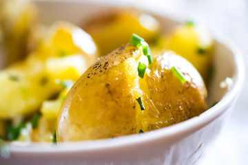 Baked potatoes with chives in a bowl
