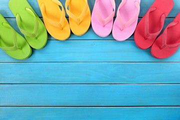 Flip flops or flipflop in a row line semi circle top border with old blue wood deck decking summer beach vacation holiday family team teamwok photo - obrazy, fototapety, plakaty