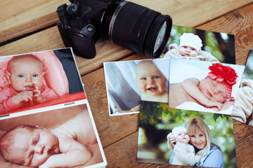 Children's photos and camera on a wooden background.
