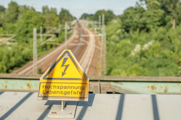 Warnung vor Hochspannung an Bahngleisen