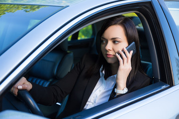 successful business woman talking on smartphone in her car