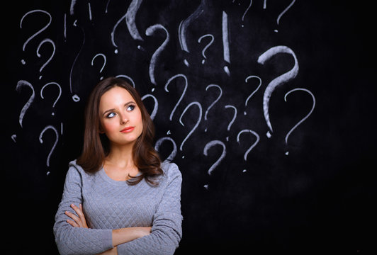 Young girl with question mark on a gray background