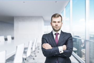 CEO with crossed hands in the modern conference room. A concept of successful business. Panoramic office, New York City view.