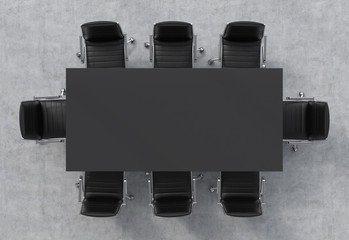 Top view of a conference room. A black rectangular table and eight black leather chairs around. 3D...