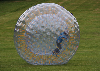Mit einem Laufball auf einer Wiese unterwegs