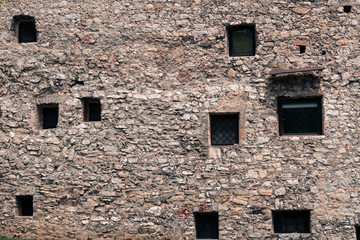 Windows of various sizes and layouts in the medieval stone wall.
