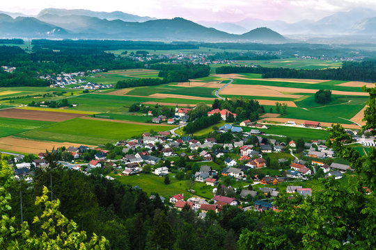 View from the hill of the typical european village, fields and mountains.