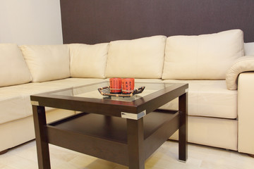 Coffee table and comfortable white corner leather sofa.