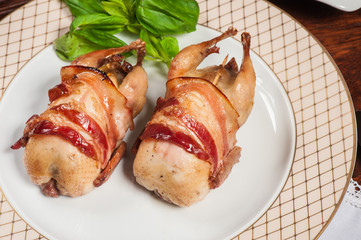 Two fried quails with bacon