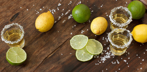 tequila lime and lemon on a wooden table - obrazy, fototapety, plakaty
