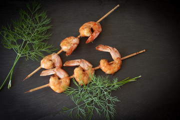 Grilled shrimp with dill on a black stone