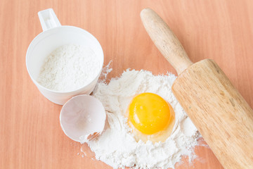 Ingredients for baking cake with egg on a wooden worktop