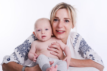 mature blonde woman holding and taking care of her lovely new born baby boy