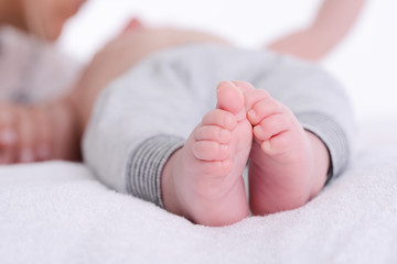 closeup shot of baby foot laying down on a white blanket