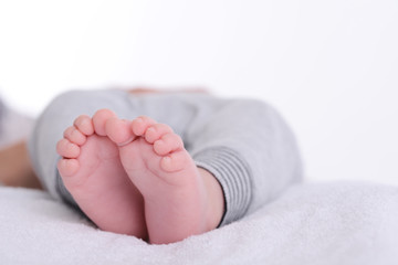 closeup shot of baby foot laying down on a white blanket