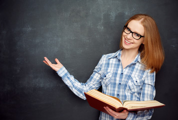 happy girl student with glasses and book from blank blackboard