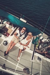 Stylish wealthy couple on a yacht