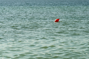 Orange Life Buoy Floating In The Middle Of The Ocean