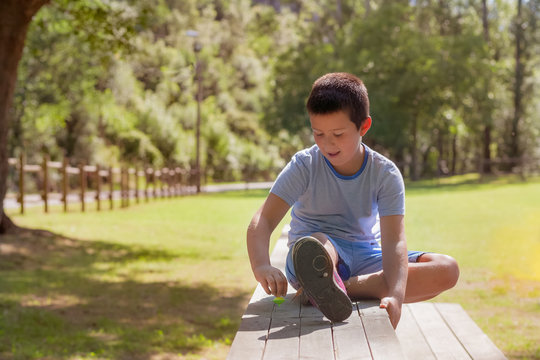 ni&ntilde;o jugando a la peonza en el parque
