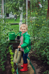 Child in Greenhouse. Garden. Vegetables. Outdoors portrait