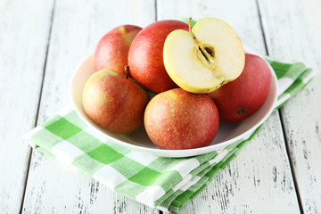 Apples in bowl on white wooden background