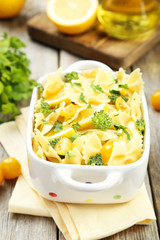 Delicious pasta with with broccoli in bowl on grey wooden backgr