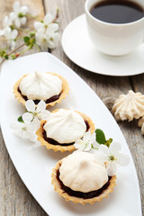 French meringue cookies in tartlet on plate on grey wooden backg