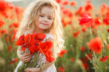 A little girl in a field of red poppies 