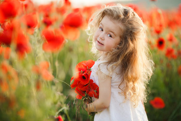 A little girl in a field of red poppies 