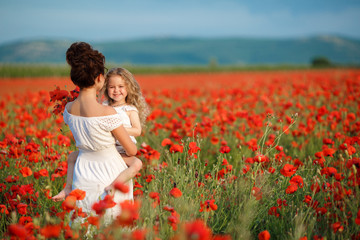 beautiful mother and little daughter in a field in summer