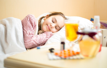 Obraz na płótnie Canvas Portrait of sick girl in sweater lying in bed