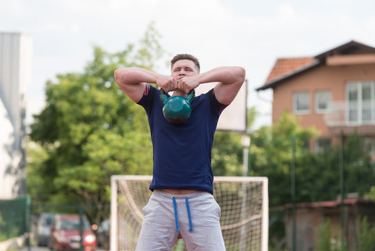 Young Man Doing Kettle Bell Exercise Outdoor