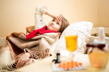 Fototapeta na wymiar sick girl with high temperature resting in bed