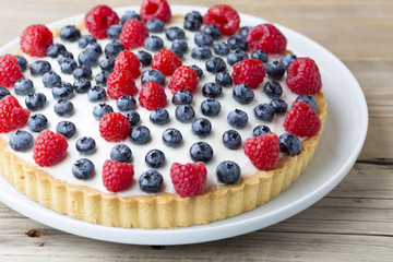 Cake with blueberries and raspberries. Confectionery product.